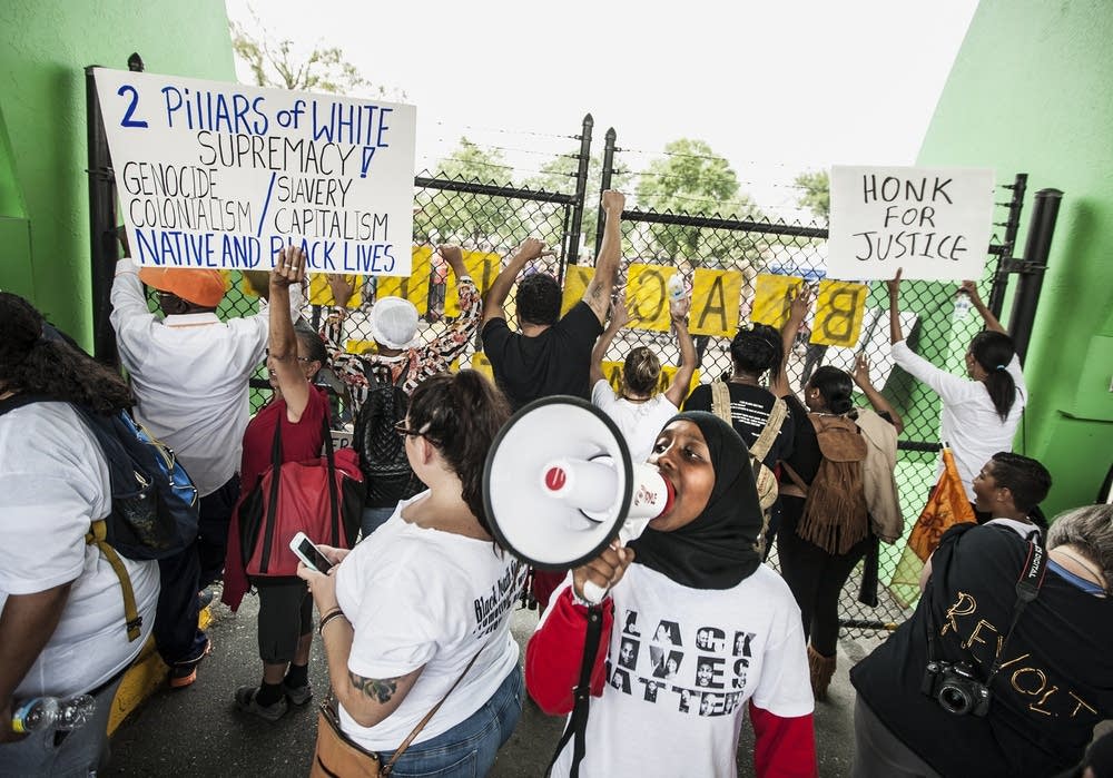 BlackFair protestors stand at the locked main gate
