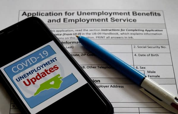 In this photo illustration, a COVID-19 Unemployment Assistance Updates logo is displayed on a smartphone on top of an application for unemployment benefits on May 8, 2020, in Arlington, Virginia. - With shops and factories closed nationwide due to the coronavirus pandemic, nearly all of the jobs created in the US economy in the last decade were wiped out in a single month. An unprecedented 20.5 million jobs were destroyed in April in the world's largest economy, driving the unemployment rate to 14.7 percent compared to 4.4 percent in March, the Labor Department said in its monthly report, the first to capture the impact of a full month of the lockdowns. (Photo by Olivier DOULIERY / AFP) (Photo by OLIVIER DOULIERY/AFP via Getty Images)