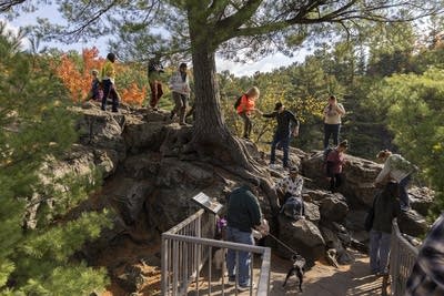 People climb rocks in a park.