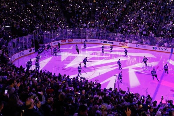 A view of the hockey rink before the game, lit up in purple lights.