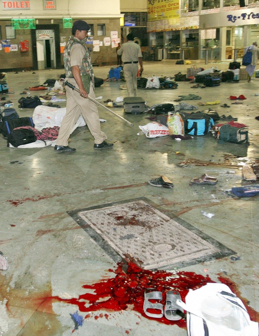 Indian policemen walk through the shooting site