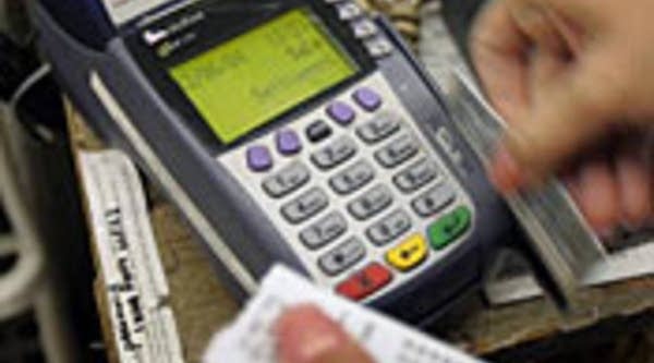 A credit card is swiped through machine at a Chicago toy store.