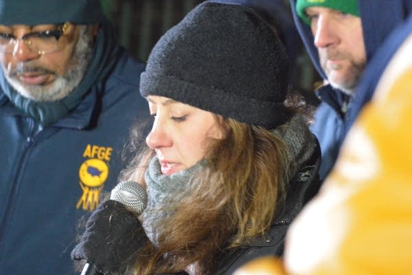 Woman speaks into mic at vigil