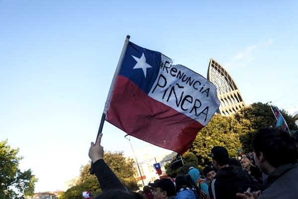 Protesters in Chile hold a flag calling for the resignation of Sebastián Piñera. (Credit: Getty Images)