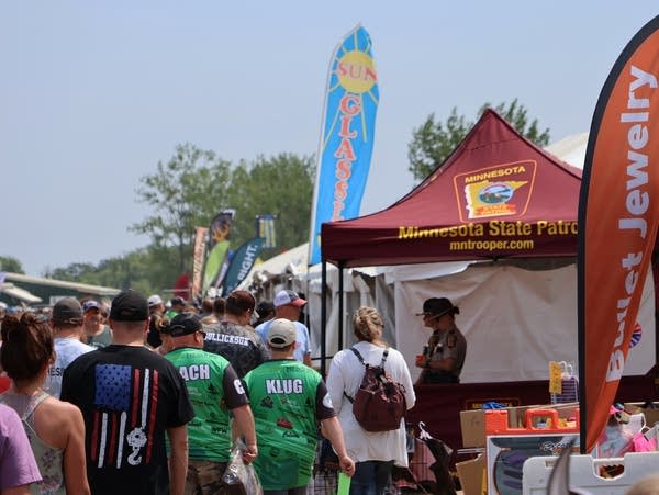 people walk past booths selling merchandise