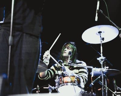 A musician plays drums onstage