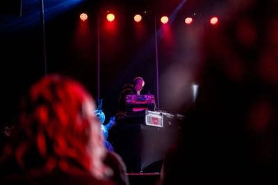 A DJ performs onstage in a music venue
