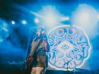 SoulFlower's Inayah El-Amin sings into a microphone at Fine Line.