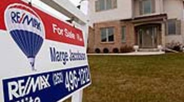 A sign sits in the front yard of a home being offered for sale in Pleasant Prairie, Wis.