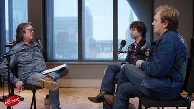 Three men having a conversation in a recording studio