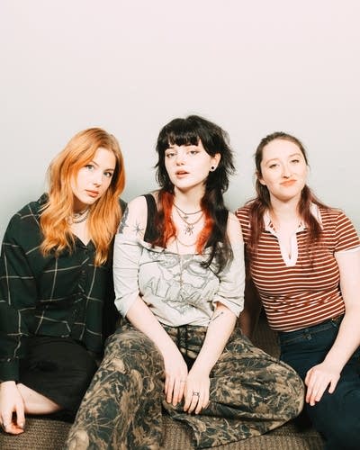 Three musicians sit together for a portrait