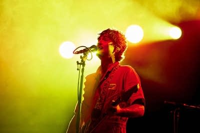 A musician sings and plays guitar onstage