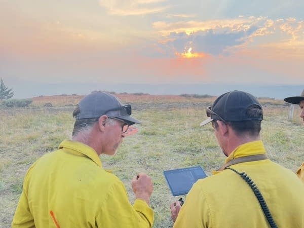 two people work with a drone pilot