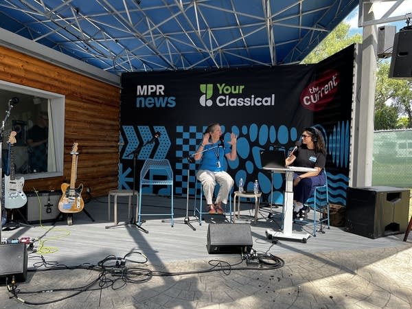 Two people speak on stage.