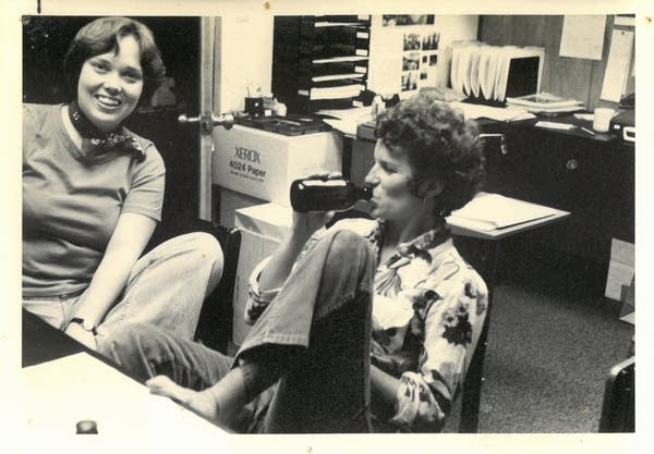 Two women relax in an office environment.