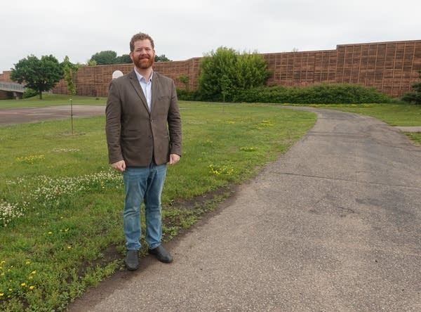 Man in suit stands near wall barrier