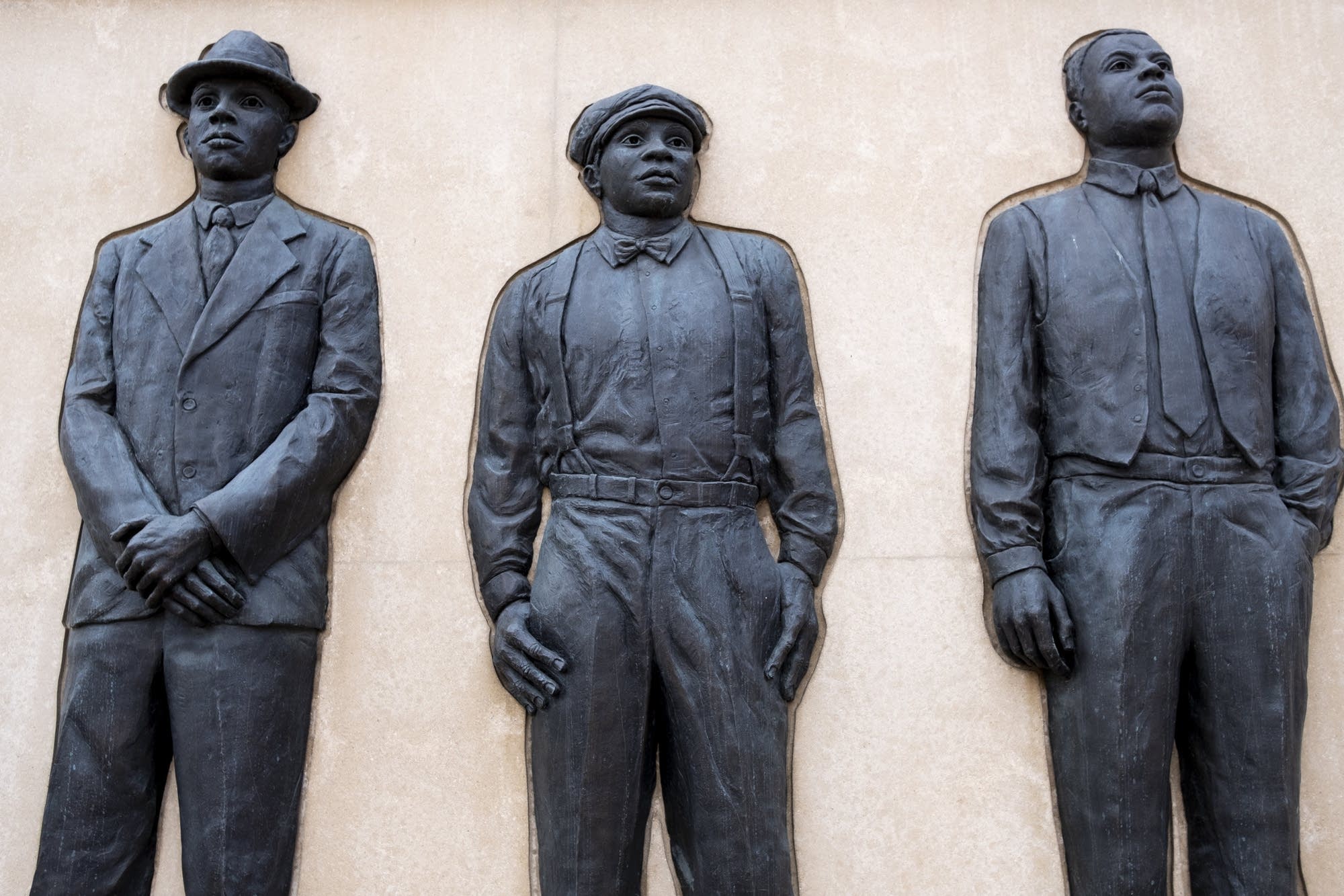 Metal castings of images of Elias Clayton, Elmer Jackson and Isaac McGhie.