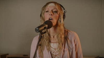 A musician sings in a recording studio