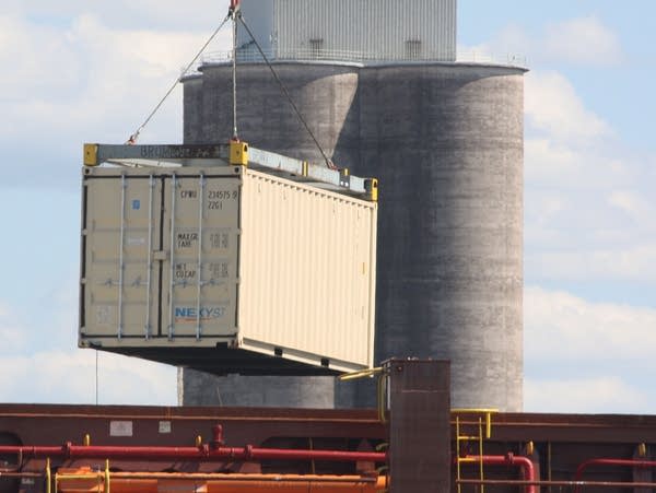 A shipping container hoisted in the air