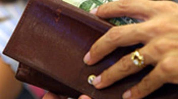 A customer prepares to spend her money.