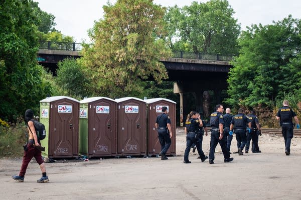 Police walk into an encampment
