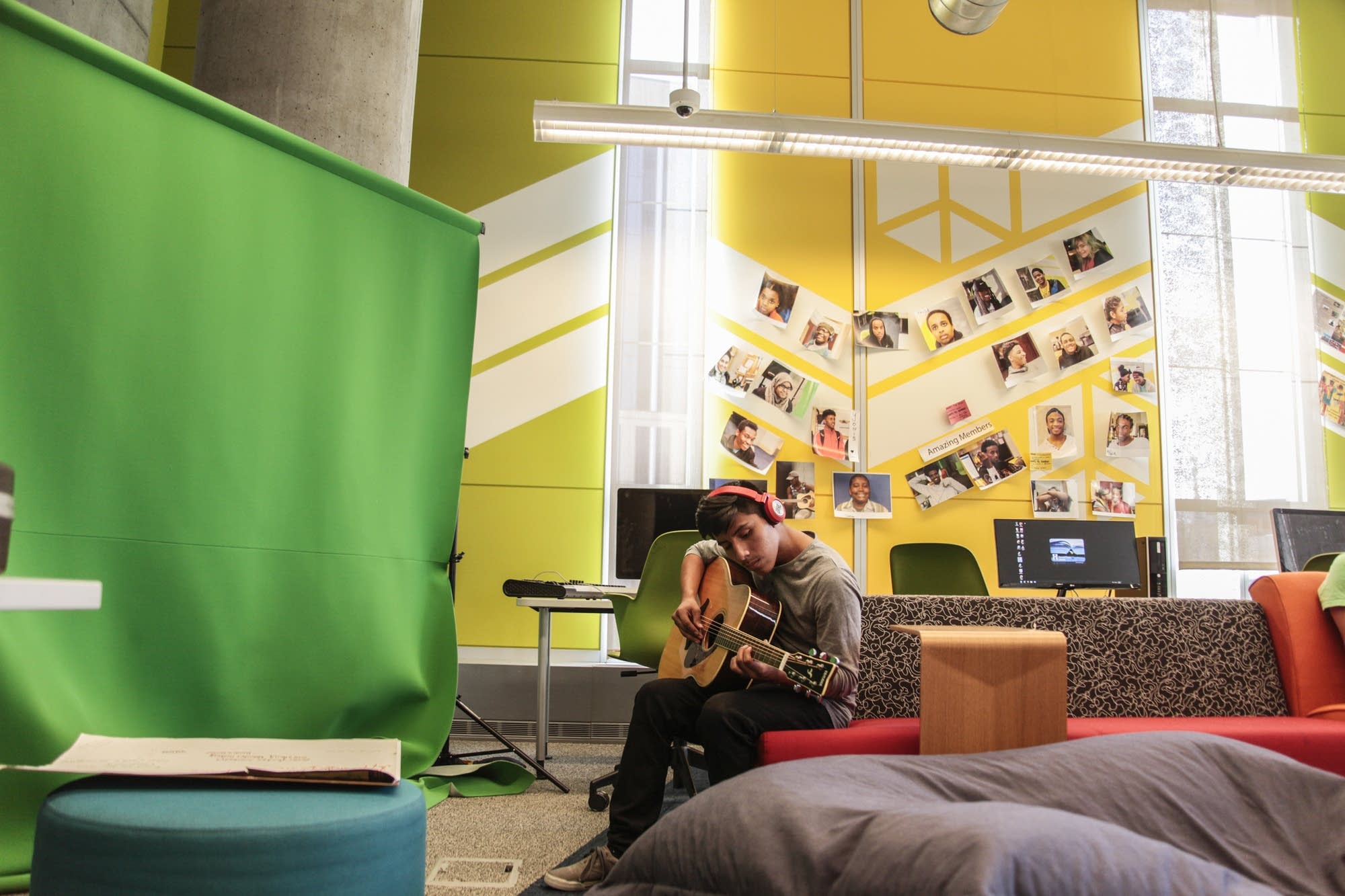 Donny Chiqui plays the guitar by the green screen at the teen tech center.