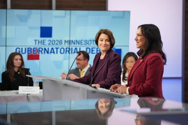 two candidates stand behind podiums