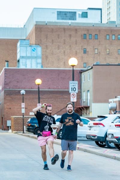 Two guys in light clothing walk along a street in Rochester, Minnesota