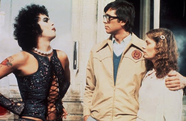 Three actors engage in dialogue in a scene from a film