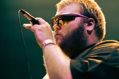 man with sunglasses singing on stage