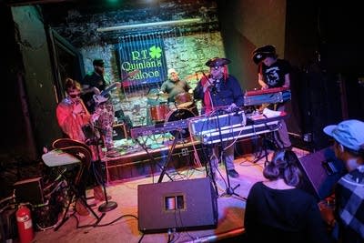 Five musicians performing onstage