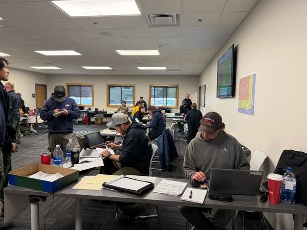 A team works on laptops in a conference room.