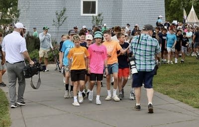 A group of students lead a march through a park as part of a protest.