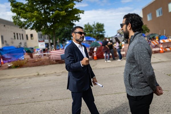 Two men speak in the street