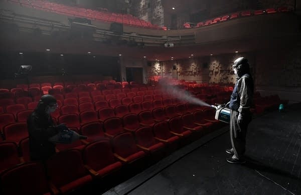 A South Korean worker sprays disinfectant in a theatre in Seoul.