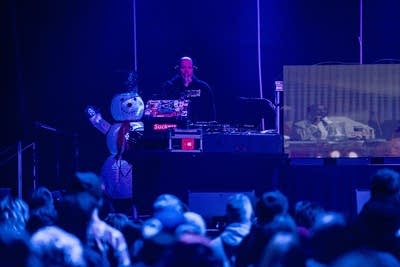 A DJ performs onstage in a music venue