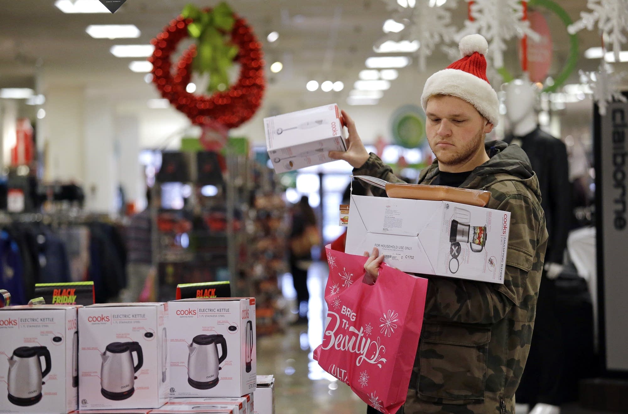 Joey Ellis adds to his armful of items while shopping for deals.