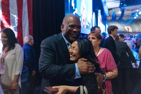 A man and woman hug backstage.