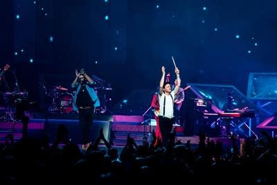 A band performing onstage in a large arena
