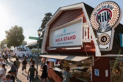 People wait outside a milk stand