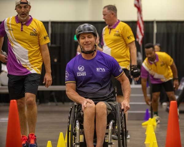 Man in purple shirt smiles.