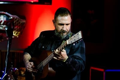 A musician plays guitar onstage