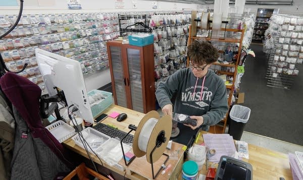 Lisa Eldridge weighs jump rings to fill an order for a customer.