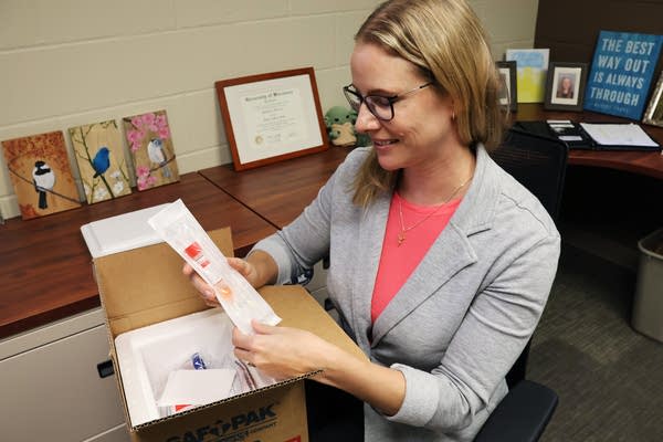 A woman unpacks a test kit