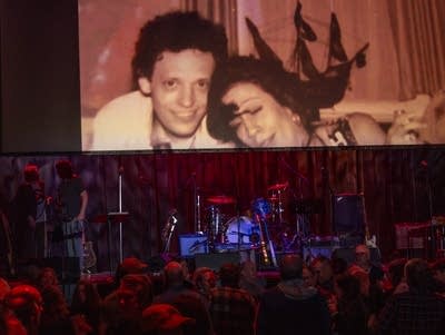 A slideshow of photos of Slim Dunlap shows on a giant screen.