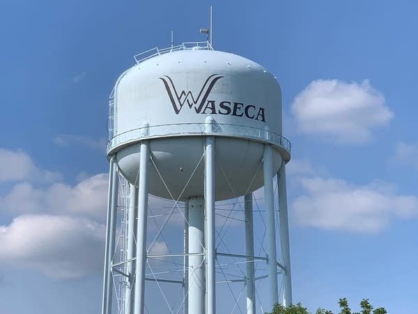 A water tower against a partly cloudy sky