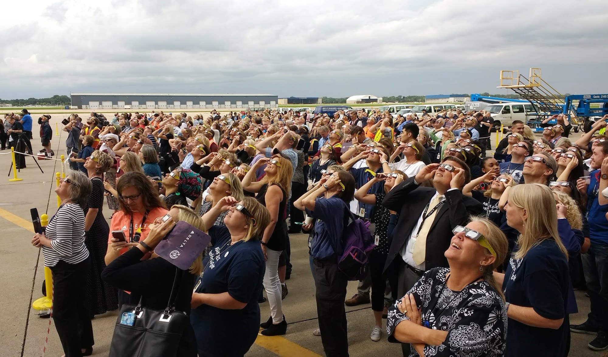 Airport employees stand outside to watch the eclipse.