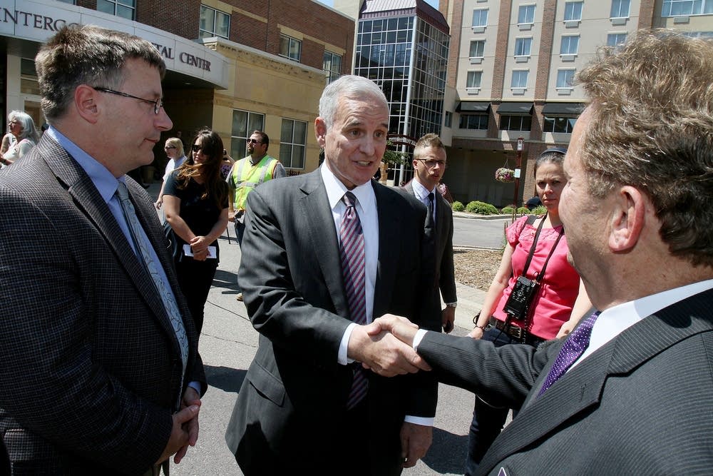 Gov. Mark Dayton shakes hands with local officials