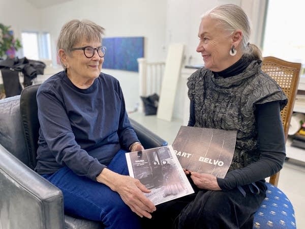 two women holding photos