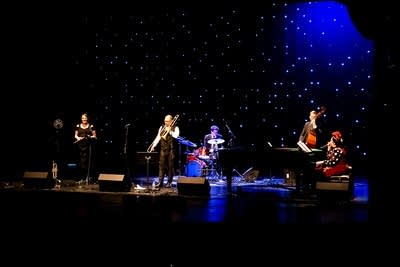 A band performing onstage in a theater